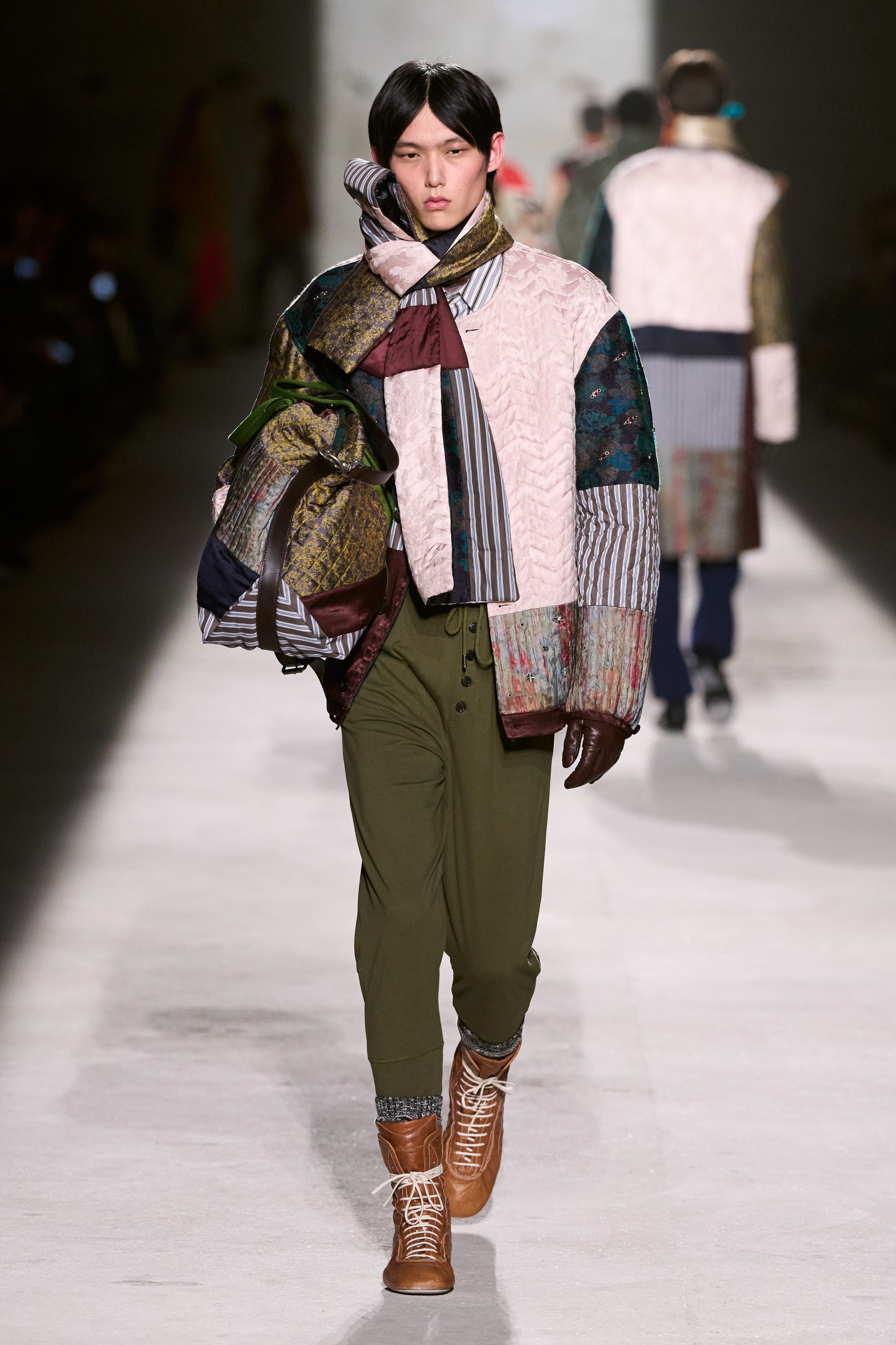 Dries Van Noten 2026秋冬以高度成熟的综合色彩与织物语言，继续书写其标志性的“文化层叠美学”。民族图案针织、拼接围巾、军装轮廓与优雅大衣在行走中形成复杂而克制的视觉节奏，色彩看似丰富却始终维持理性秩序。这是一种属于思想型穿着者的浪漫，不依赖情绪爆发，而通过织物、比例与色块的精密组合，构建出安静却极具深度的男性诗意-顽石频道趋势研究